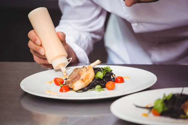 Chef-kok, zetten saus op een schotel — Stockfoto