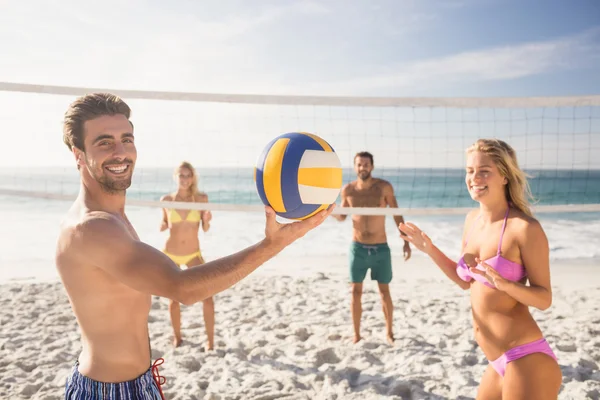 Друзья играют в пляжный волейбол — стоковое фото