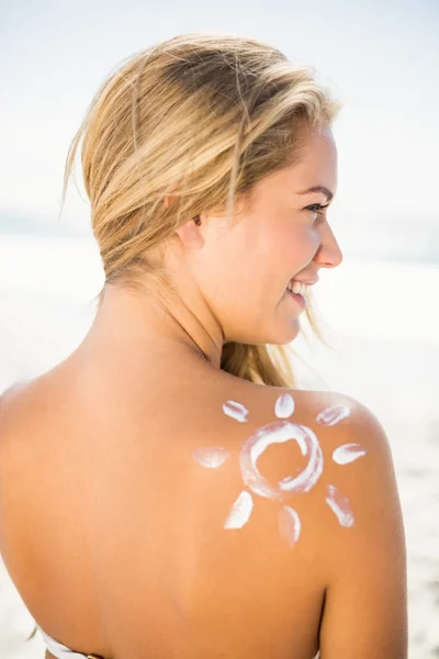 Usmívající se žena s opalovací krém na kůži — Stock fotografie