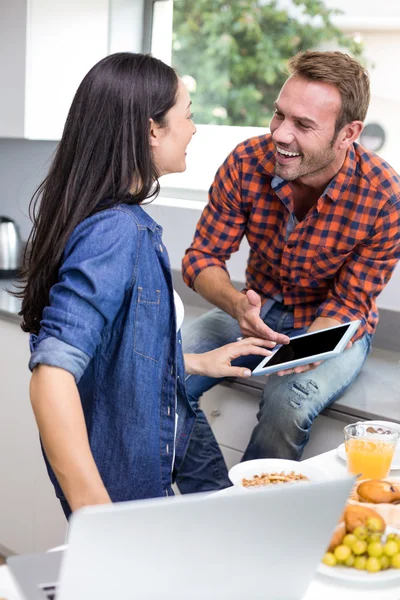 Couple interagissant en utilisant un ordinateur portable et une tablette numérique — Photo