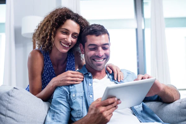 Mladý pár pomocí digitální tablet na pohovce — Stock fotografie