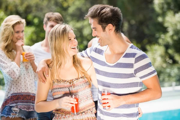 Casal jovem sorrindo e tomando suco juntos — Fotografia de Stock