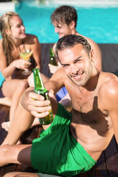 Young man having beer at the swimming pool — Stock Photo, Image