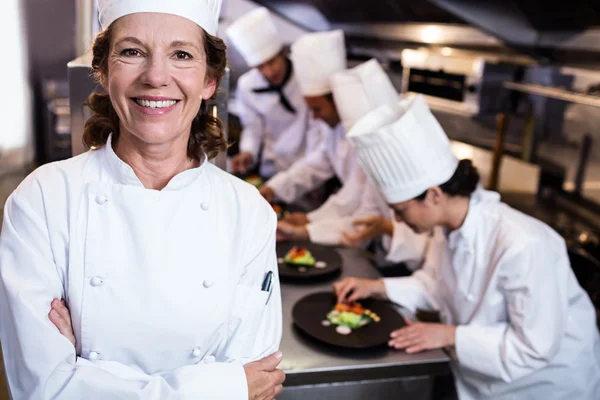 Head chef smiling in busy kitchen — Stock Photo, Image