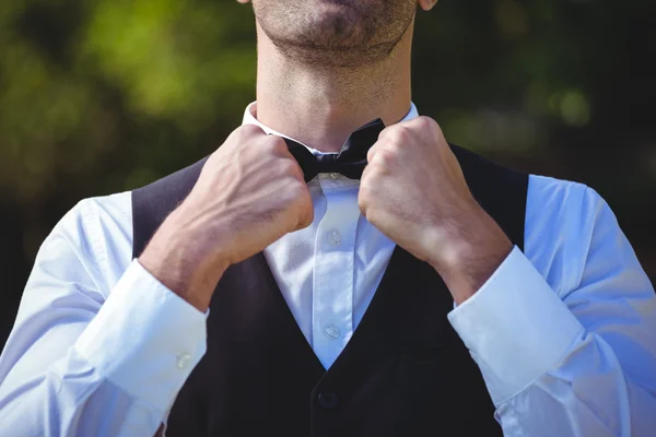 Handsome waiter reattaching his bow tie — Stock Photo, Image