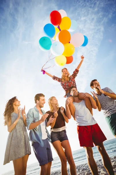 Amici che ballano sulla sabbia con palloncino — Foto Stock