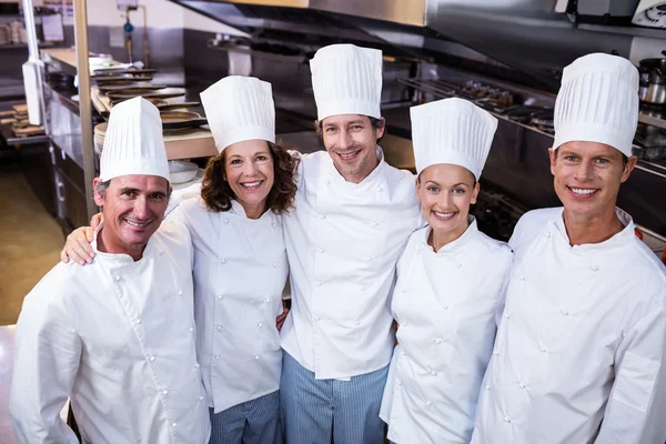 Chef-koks team staande in commerciële keuken — Stockfoto