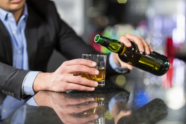 Businessman pouring whisky in glass — Stock Photo, Image