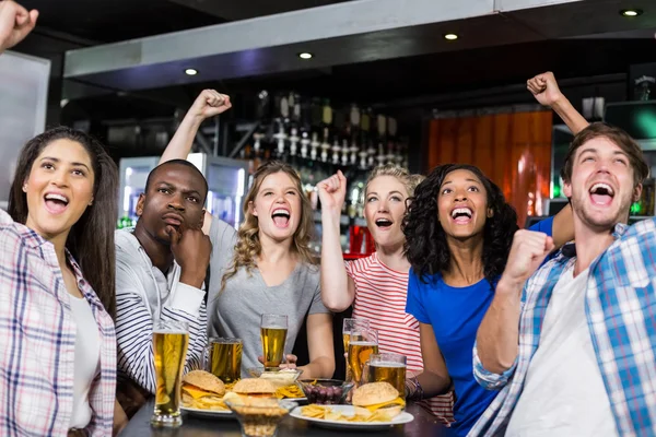 Amigos felices tomando una copa y viendo deporte — Foto de Stock