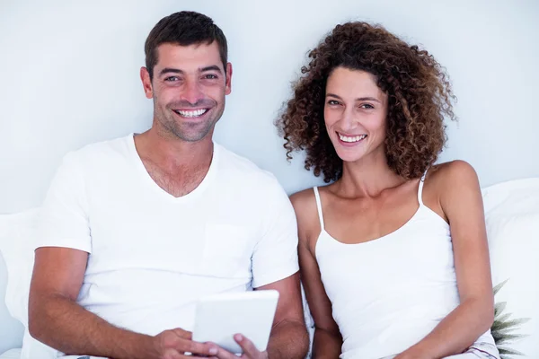 Portret van de gelukkige paar met behulp van digitale tablet op bed — Stockfoto
