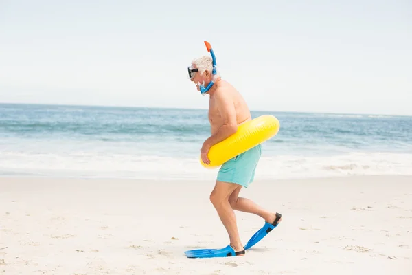 Homme âgé avec anneau de natation et palmes à la plage — Photo