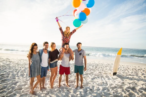 Друзья позируют с воздушным шаром на песке — стоковое фото