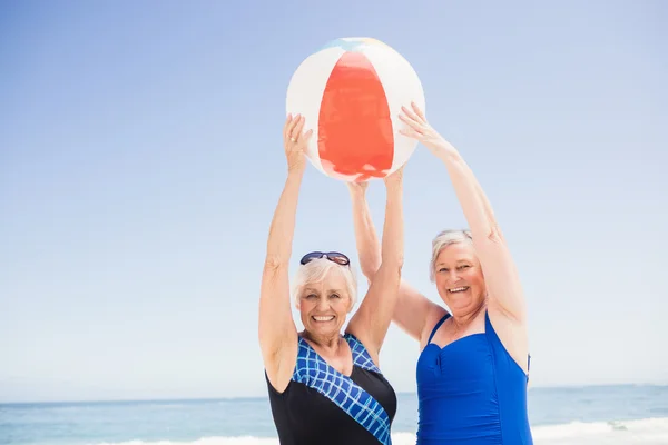 Mujer mayor sosteniendo pelota de playa — Foto de Stock