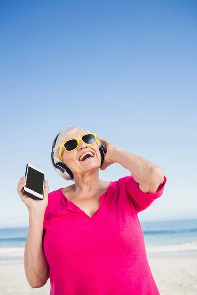 Senior vrouw luisteren muziek met hoofdtelefoon — Stockfoto