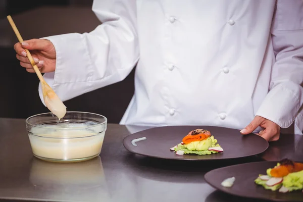 Koch legt Sauce auf einen Teller — Stockfoto