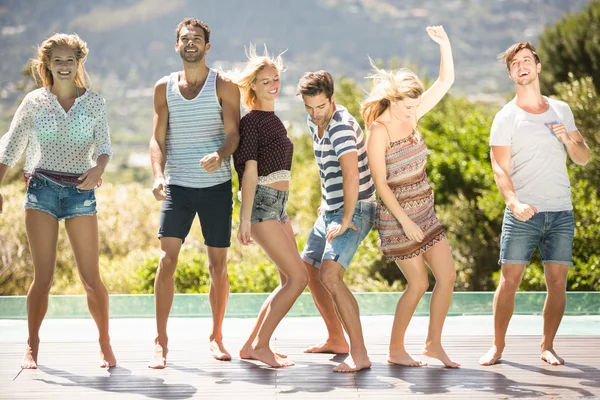 Groep vrienden dansen bij zwembad — Stockfoto