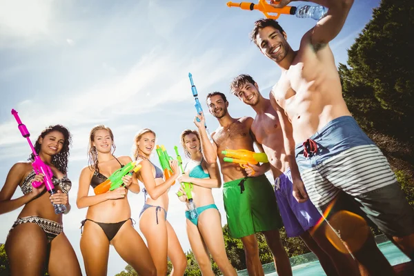 Happy vänner står med vattenpistoler — Stockfoto