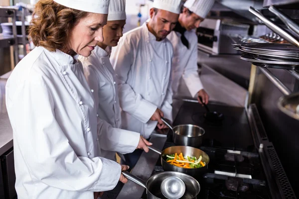 Chefs preparing food in kitchen — Stock Photo, Image