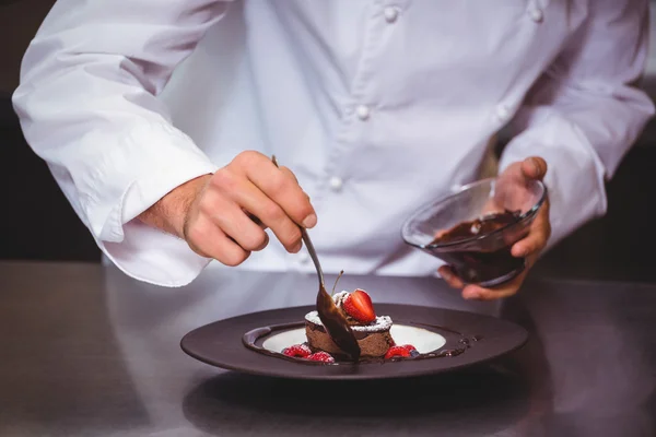 Chef poniendo salsa de chocolate en un postre — Foto de Stock