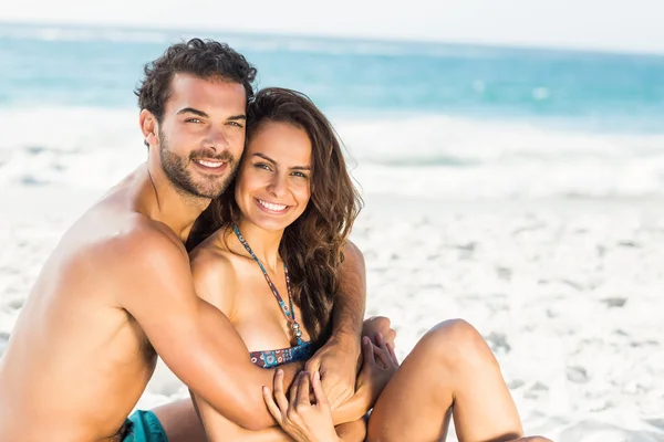 Pareja feliz sentada en la playa —  Fotos de Stock