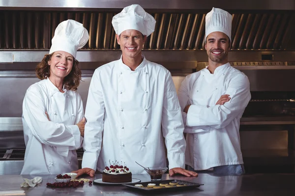 Chefs heureux et fiers de présenter le gâteau qu'ils viennent de faire — Photo