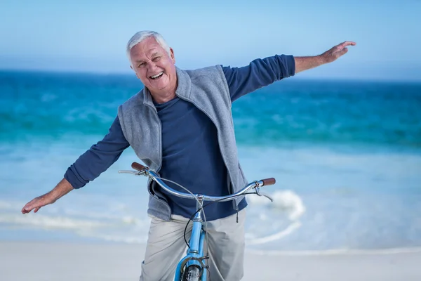 Senior man met een fiets uitdijende wapens — Stockfoto