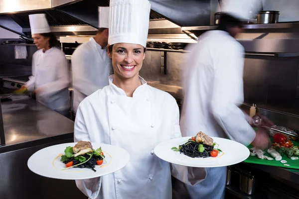 Gelukkig chef-kok presenteert haar voedsel-platen — Stockfoto