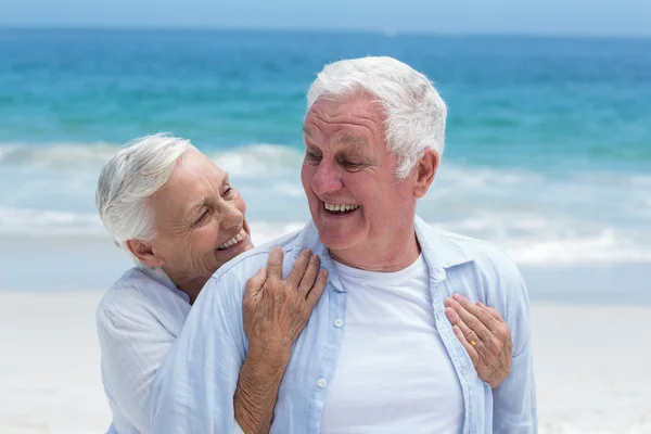 Couple aîné embrassant avec les bras autour — Photo