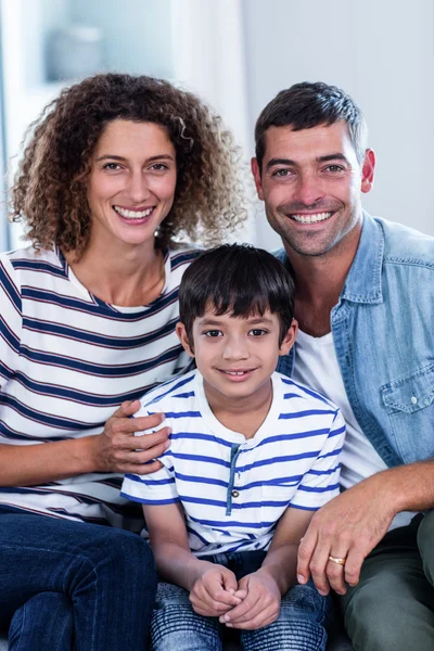 Portrait of happy family sitting together on sofa — Stock Photo, Image