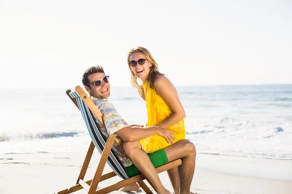 Mulher sentada no colo dos homens na praia — Fotografia de Stock