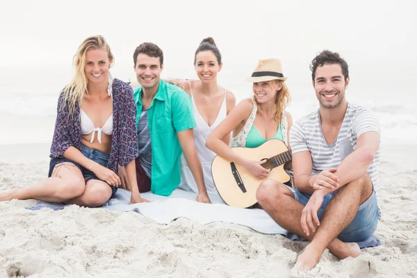 Vänner sitter på stranden med gitarr — Stockfoto