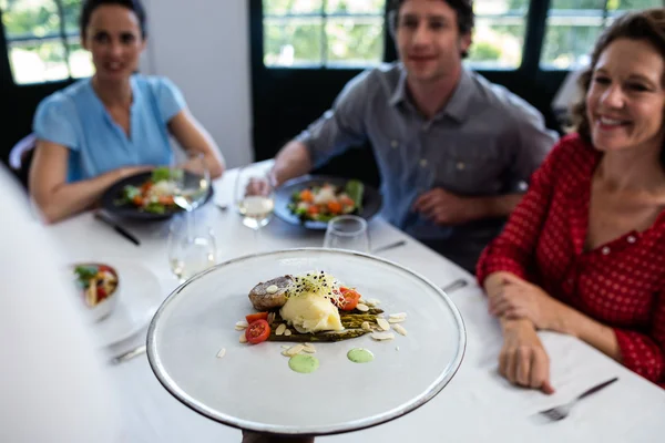 Kellner serviert Mahlzeit für eine Gruppe von Freunden — Stockfoto