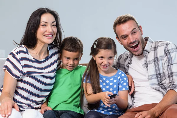 Lyckliga familjen tittar på TV — Stockfoto