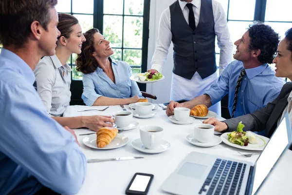 Servitören som serverar sallad till företagare — Stockfoto