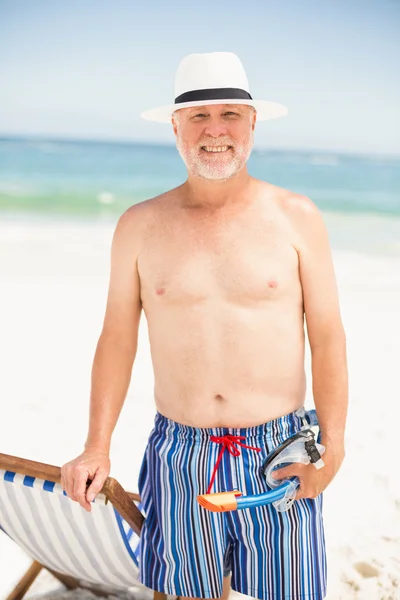 Homem sênior em pé ao lado da cadeira de sol — Fotografia de Stock