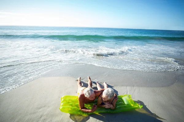 Senior couple lying on air mattress — Stock Photo, Image