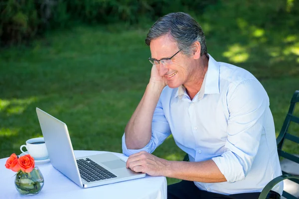 Casual businessman using laptop daydreaming — Stock Photo, Image