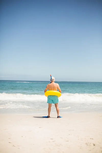 Homme âgé avec anneau de natation et palmes à la plage — Photo