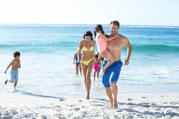 Família feliz andando na praia — Fotografia de Stock
