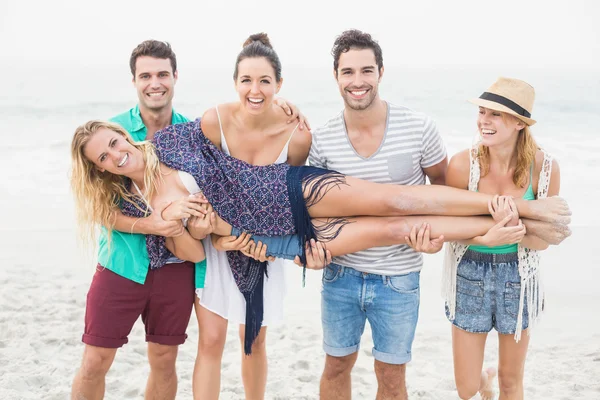 Gruppo di amici che sollevano una donna — Foto Stock