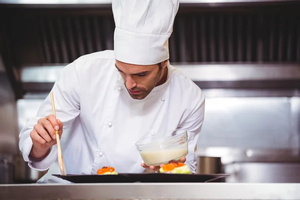 Chef-kok, zetten saus op een schotel — Stockfoto