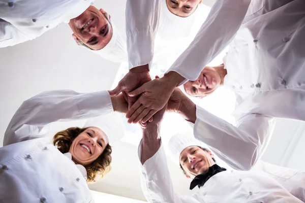 Equipe de chefs dando as mãos juntos — Fotografia de Stock