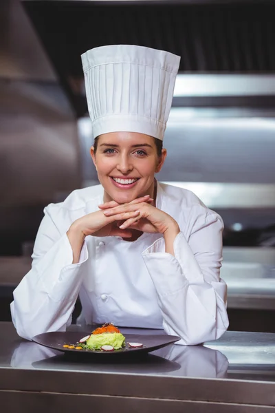 Chef-kok leunend op de teller met een schotel — Stockfoto