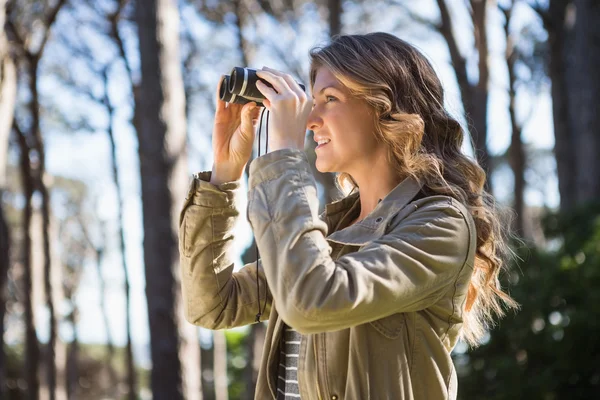 Woman using binoculars — Stock Photo, Image