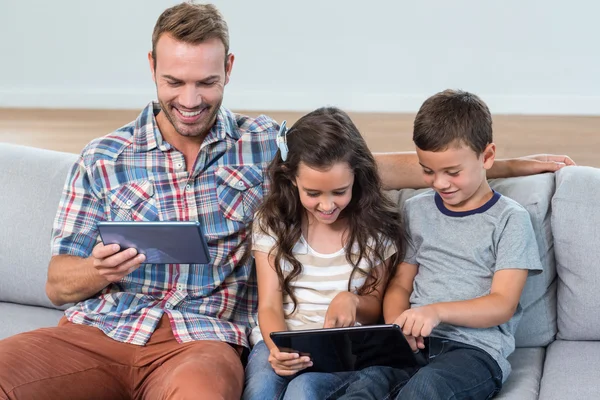 Pai e irmãos usando tablet digital — Fotografia de Stock