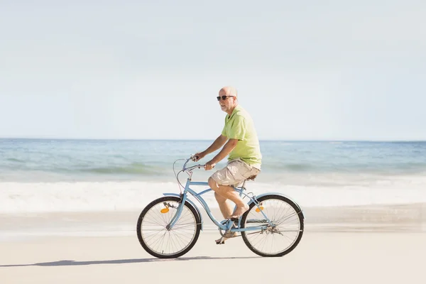 Smiling senior man riding bike — Stock Photo, Image