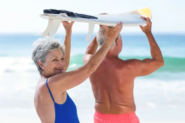 Söt äldre par hålla en surfbräda — Stockfoto