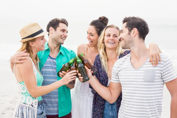 Grupo de amigos brindando garrafas de cerveja na praia — Fotografia de Stock