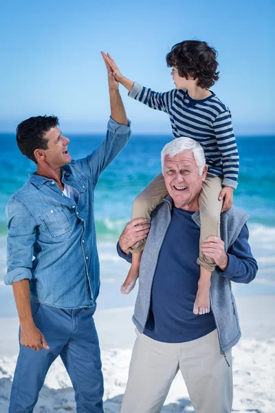 Membros masculinos da família brincando na praia — Fotografia de Stock