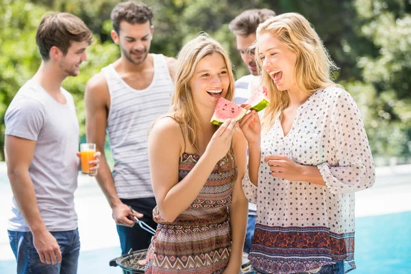 Mujeres jóvenes sonriendo y teniendo una rebanada de sandía — Foto de Stock